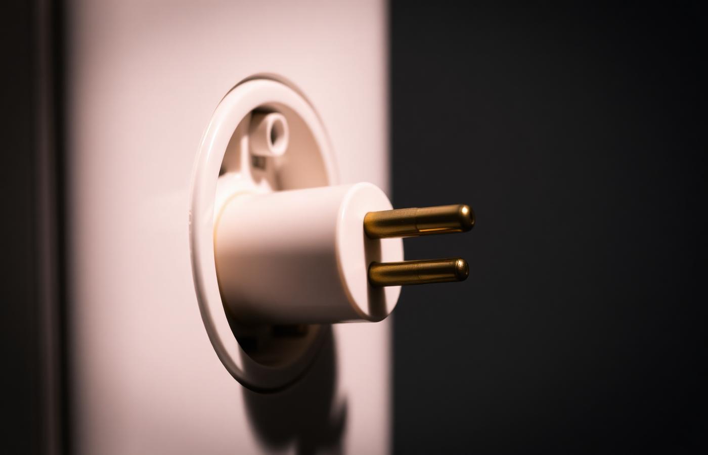 UK 3-pin plug snapping into a wall socket